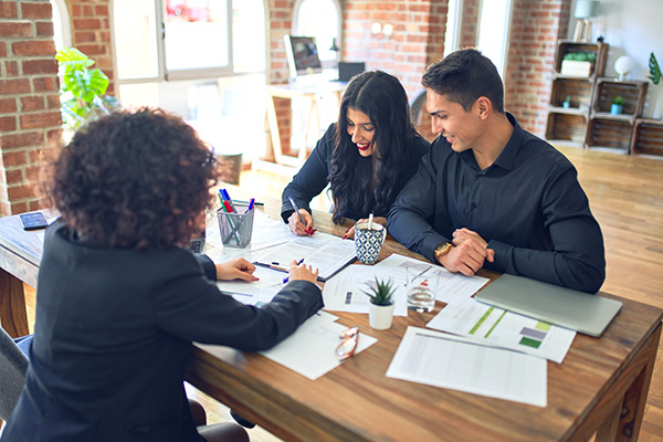 Couple completing a Mortgage Loan Application with a Loan Officer in Person using form 1003 Uniform Residential Loan Application